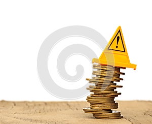 Financial risk. Coins falling and Warning label on whitebackground