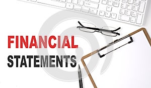 FINANCIAL STATEMENTS text written on white background with keyboard, paper sheet and pen