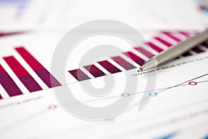 Financial statistics documents ball pen infographics at office table