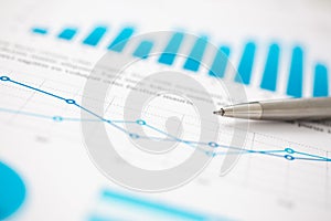 Financial statistics documents ball pen infographics at office table