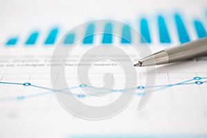 Financial statistics documents ball pen infographics at office table