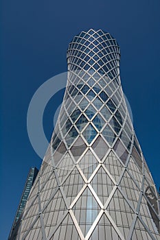 Financial success concept. Modern skyscraper on blue background (Qipco Tower, Tornado Tower), closeup, bottom view