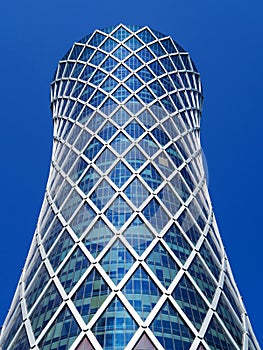 Financial success concept. Modern skyscraper on blue background (Qipco Tower, Tornado Tower), macro