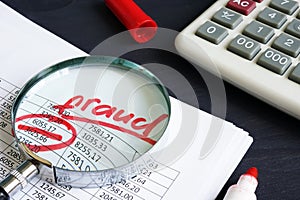 Financial or taxes fraud. Business report and magnifying glass.