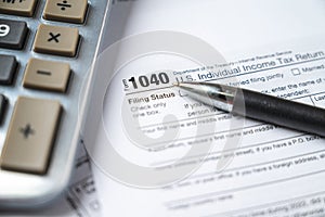 Financial time tax return forms with pen and calculator