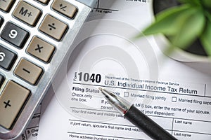 Financial time tax return forms with pen and calculator