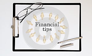 Financial Tips text on sheet with wooden peopl