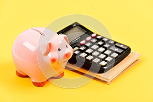 Financial wellbeing. Calculate profit. Piggy bank pink pig and calculator. Economics and finance. Credit concept. Money