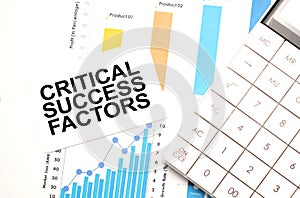 financing availabe text concept. Office workplace table with calculator, graphs, reports and the text CRITICAL SUCCESS FACTORS on