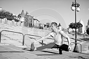Find balance. Man workout outdoors urban background. You should stretch muscles after workout to achieve best result