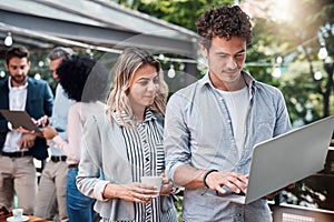 They find the best ideas online. two businesspeople working together on a laptop outdoors.