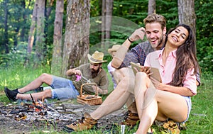 Find companion to travel and hike. Friends relaxing near campfire after day hiking or gathering mushrooms. Summer