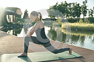 Find harmony. Full length shot of relaxed woman stretching her body while doing yoga on a mat in nature