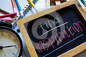 Find inspiration on phrase colorful handwritten on chalkboard, alarm clock with motivation and education concepts.