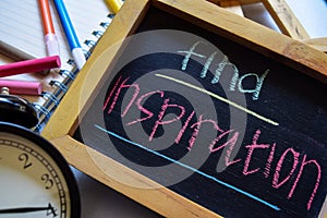 Find inspiration on phrase colorful handwritten on chalkboard, alarm clock with motivation and education concepts.