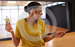 Find that perfect beat to match your step. An attractive young dancer listening to music on her headphones in a dancel