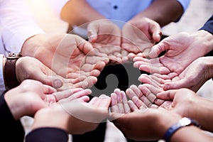 We find strength in prayer. a group of people holding out their palms in a circle outside.