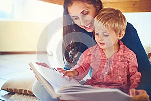 Finding joy in new tales. Shot of a mother reading a book with her little son at home.