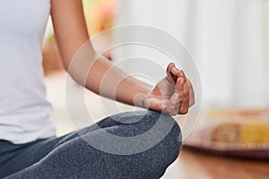 Finding your inner peace. Shot of an unrecognizable woman doing a yoga pose with her legs grossed and seated on the