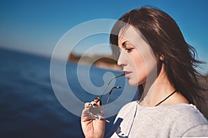 Fine art portrait of a beautiful adult woman on the sea river on the pier. woman thought about something important