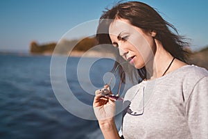 Fine art portrait of a beautiful adult woman on the sea river on the pier. woman thought about something important