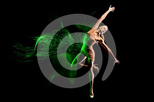 Fine art portrait of beautiful woman dancer in green sparkles