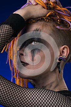 Fine art portrait beauty woman with colored dreadlocks and spooky black stage makeup painted on face