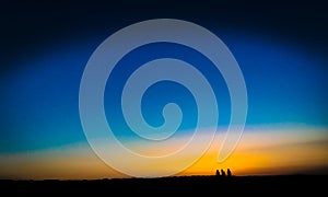 Fine art style image of three people waiting for the sunset