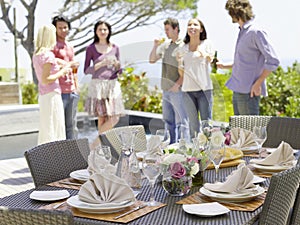 Fine Dining Table Setting With Friends In Background