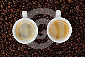 Fine espresso in cup on coffee beans