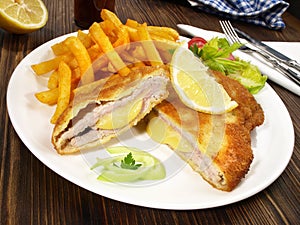 Fine Meat - Cordon Bleu with French Fries on wooden Background