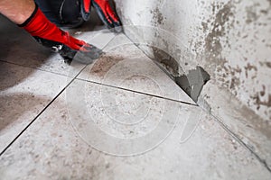 Fine precise accurate work of a tiler when laying tiles on the floor