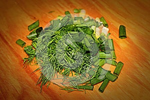 Finely chopped green dill and onions on a chopping Board