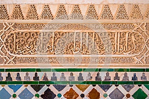 Finely decorated walls in the Alhambra Palace in Granada with arabic inscriptions. Andalusia, Spain.