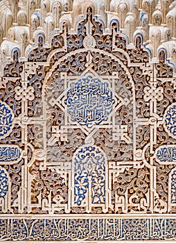 Finely decorated walls in the Alhambra Palace in Granada with arabic inscriptions. Andalusia, Spain.