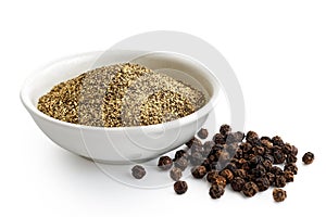 Finely ground black pepper in white ceramic bowl isolated on white. Black peppercorns.