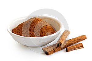 Finely ground cinnamon in white ceramic bowl isolated on white.