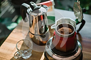 Finely ground coffee and vintage coffee maker moka pot on wooden table at home ,Selective focus