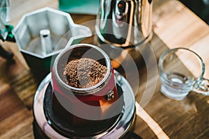 Finely ground coffee and vintage coffee maker moka pot on wooden table at home ,Selective focus