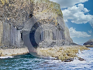 Fingal`s Cave surrounded by columns of jointed volcanic basalt rocks on the island of Staffa in Scotland photo