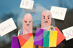 Finger art of a couple with shopping bags. Man is unhappy because he was tired of shopping