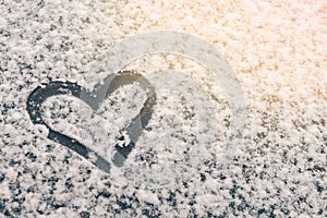 Finger-drawn heart on a snow-covered window