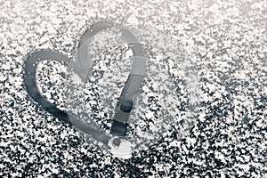 Finger-drawn heart on a snow-covered window