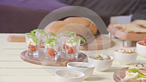 Finger food detail on table during cocktail party at home. Appetizers on table. Handheld shot. Food buffet at home party