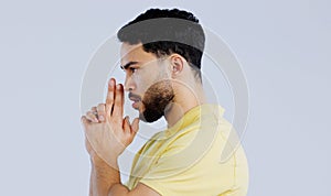 Finger gun, pointing and profile of man in studio with aim for target, shooting and spy on blue background. Secret agent