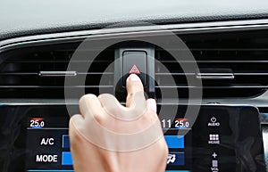 Finger hitting car emergency light button