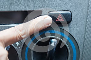 Finger hitting car emergency light button