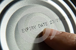 Finger pointing at the expiry date on canned food