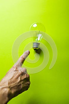 Finger pointing to a burned-out light bulb