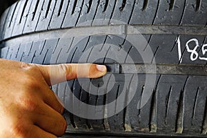 Finger pointing at tyre treadwear indicator photo